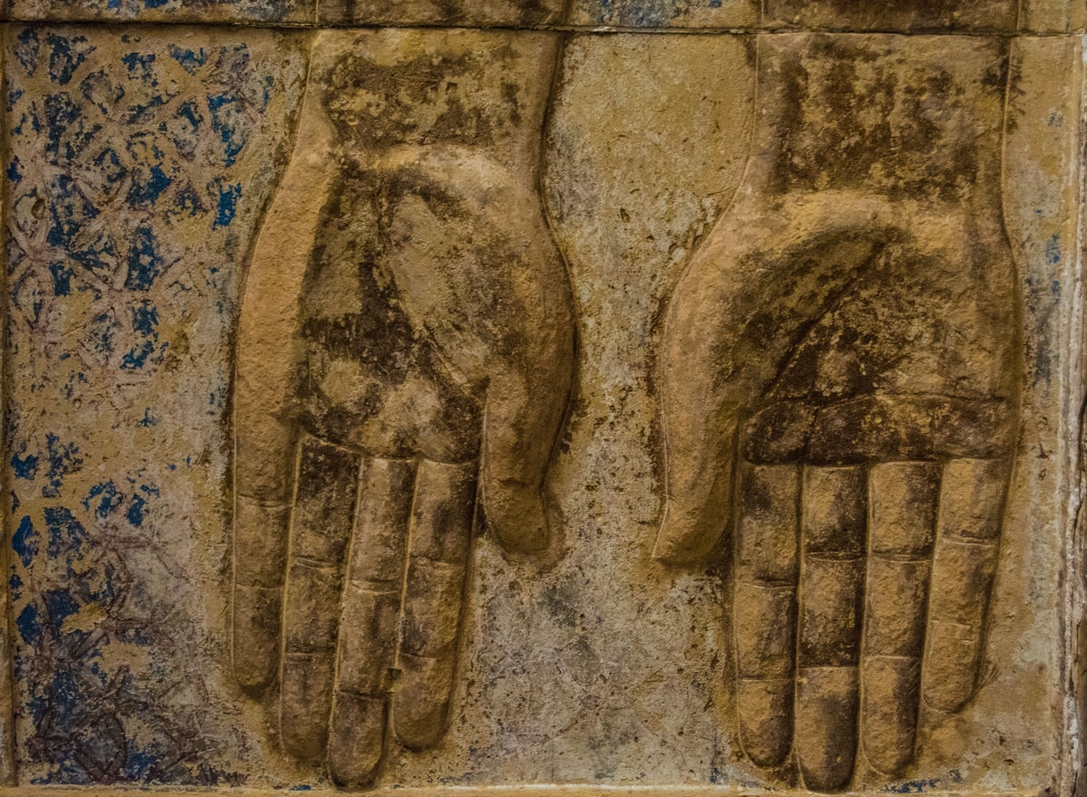 Ancient Egyptian stone relief carving showing outstretched hands at Dendera Temple