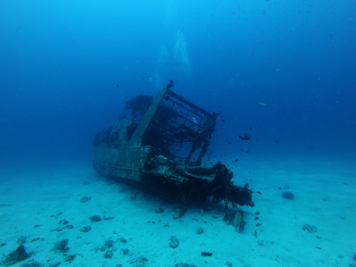 Diver exploring an underwater shipwreck in the clear blue waters of the Red Sea