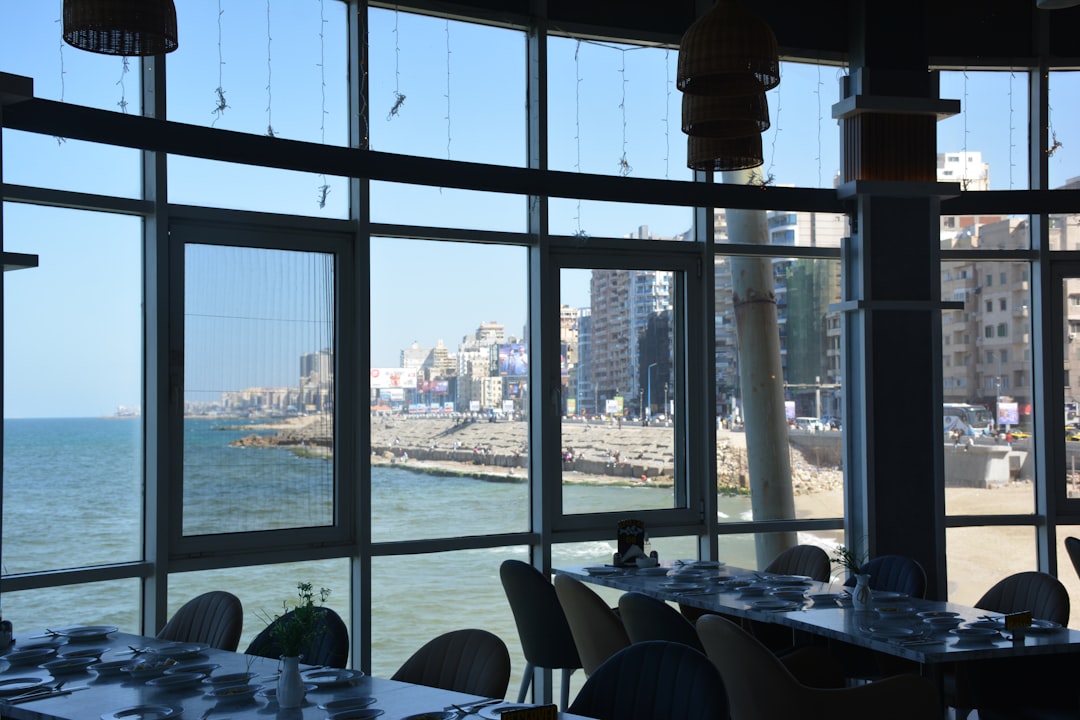 Cafe interior in Alexandria with floor-to-ceiling windows overlooking the Mediterranean Sea and Corniche