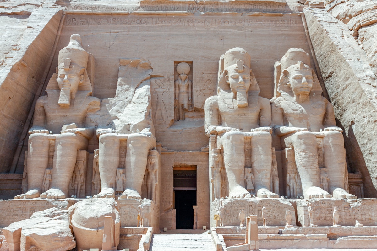 The four colossal statues of Ramesses II at the Great Temple of Abu Simbel, carved into the sandstone cliff face