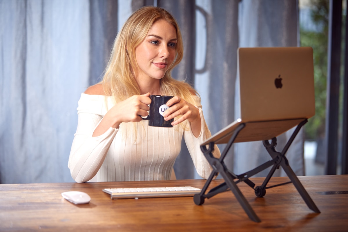 Woman working on a laptop with coffee — remote work setup