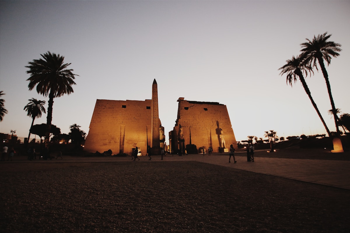 Luxor Temple illuminated at dusk with obelisk and pylon entrance, Luxor, Egypt