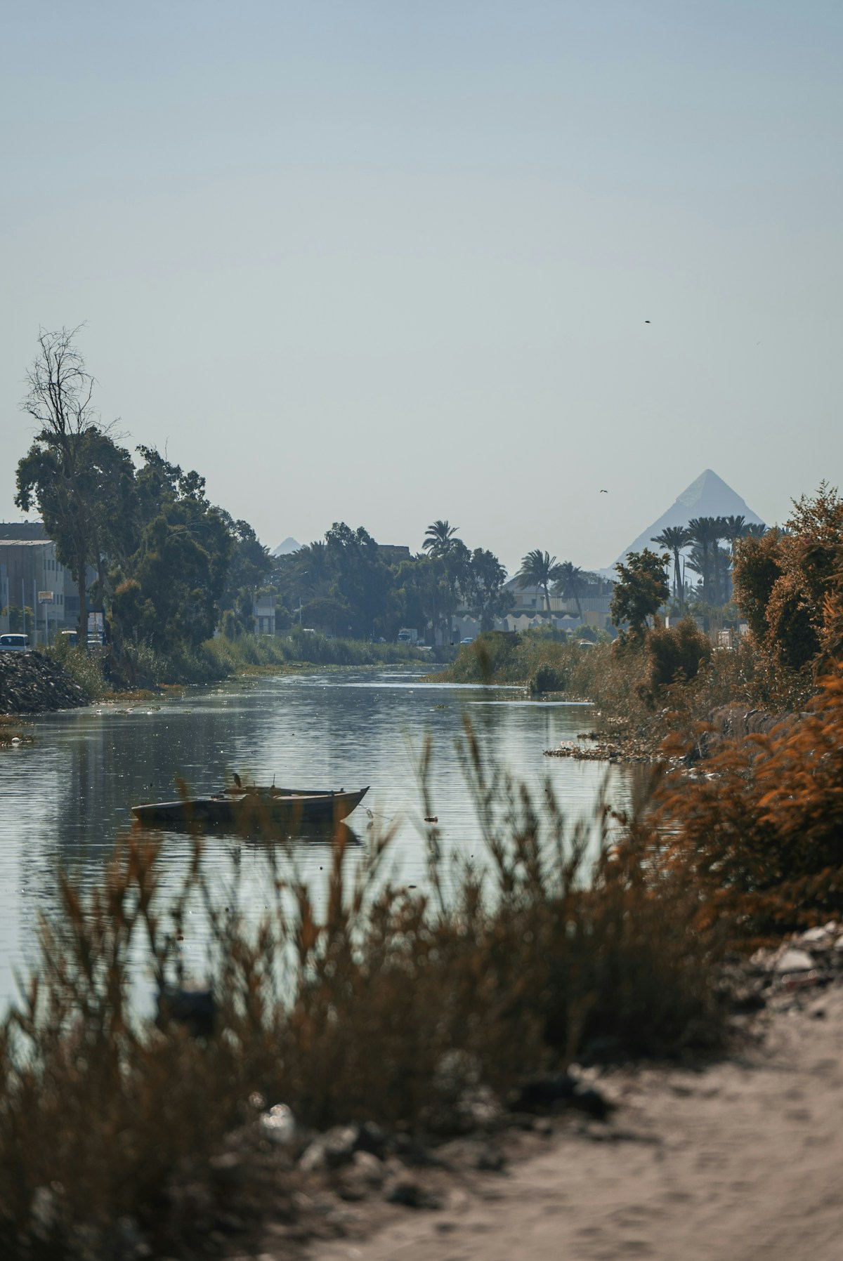 Boat on the Nile River with the Pyramids of Giza visible in the background