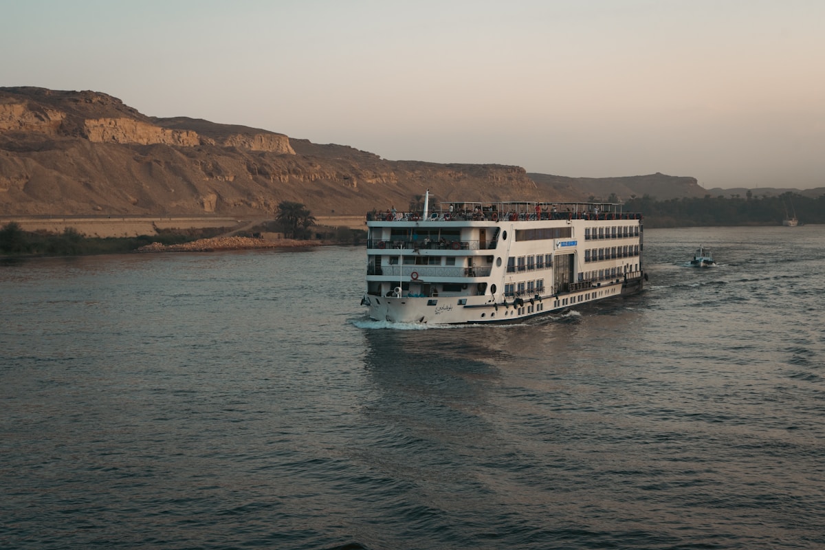 Nile cruise ship sailing past desert hills near Aswan, Egypt