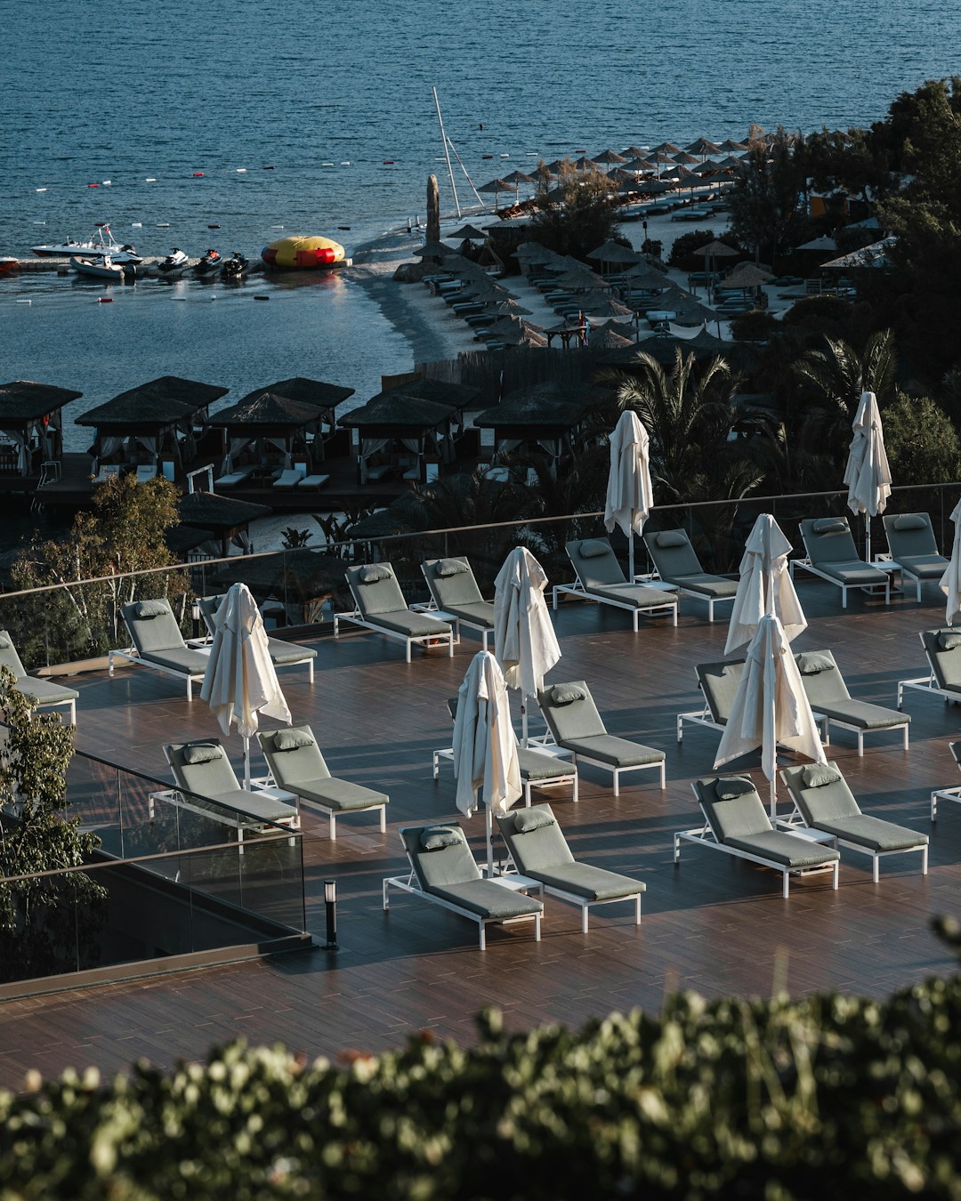 Luxury resort deck with sun loungers overlooking a Mediterranean beach