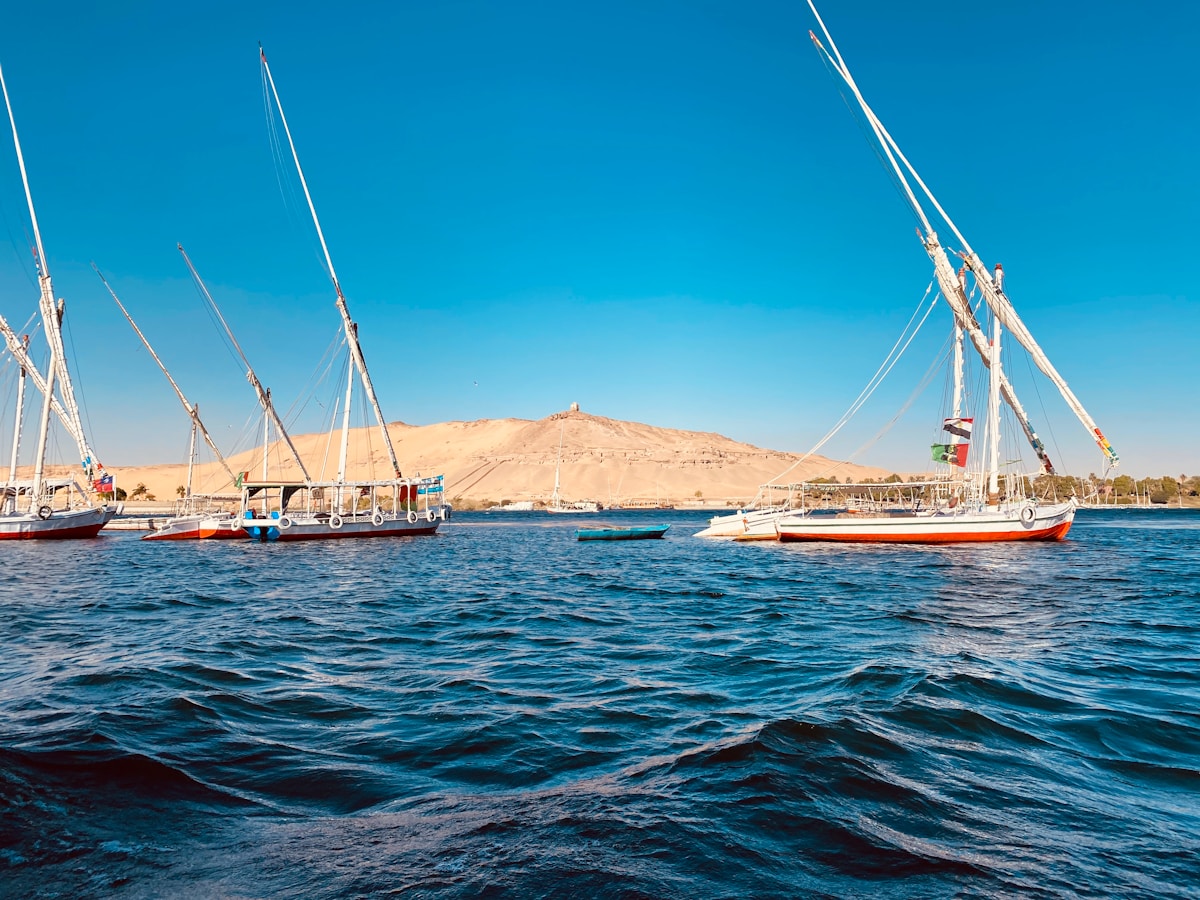 Felucca boats moored on the Nile at Aswan with desert hills behind