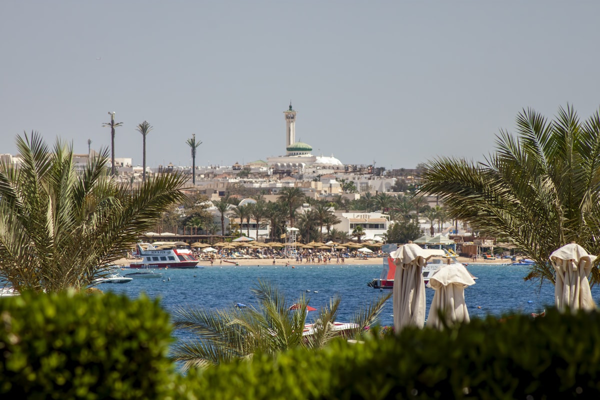 Hurghada resort waterfront with palm trees, beach umbrellas, and the Red Sea