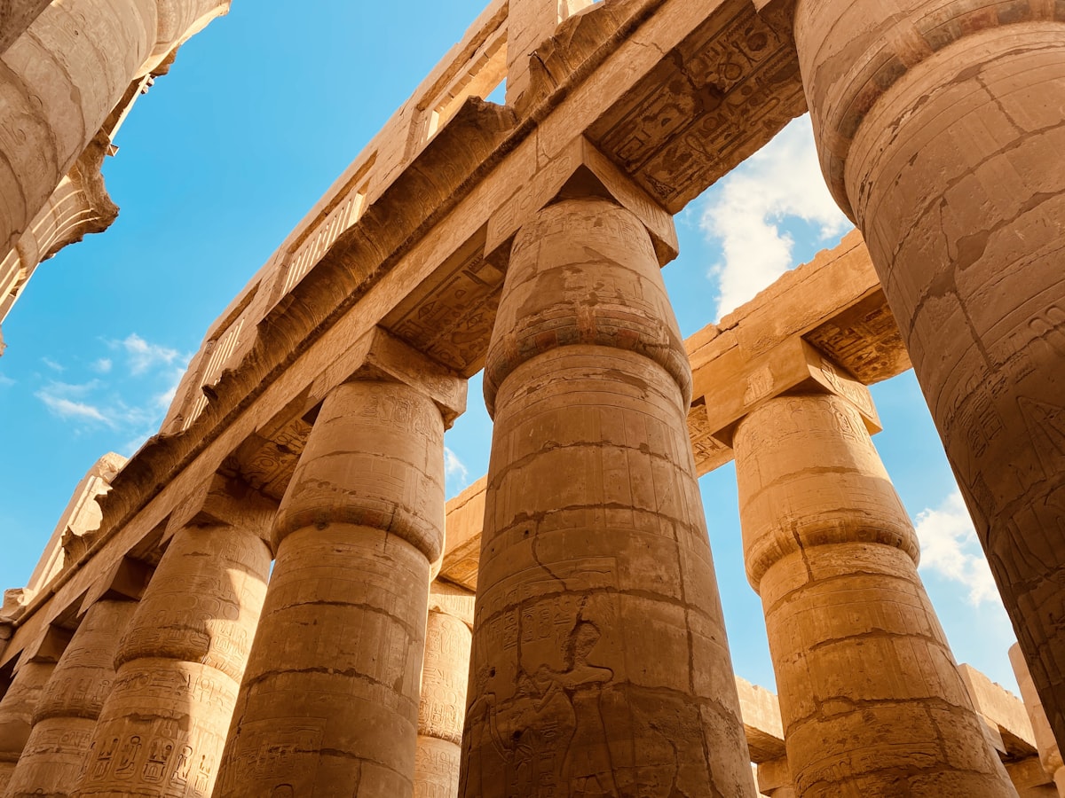 Karnak Temple great hypostyle hall columns with hieroglyphs under blue Egyptian sky