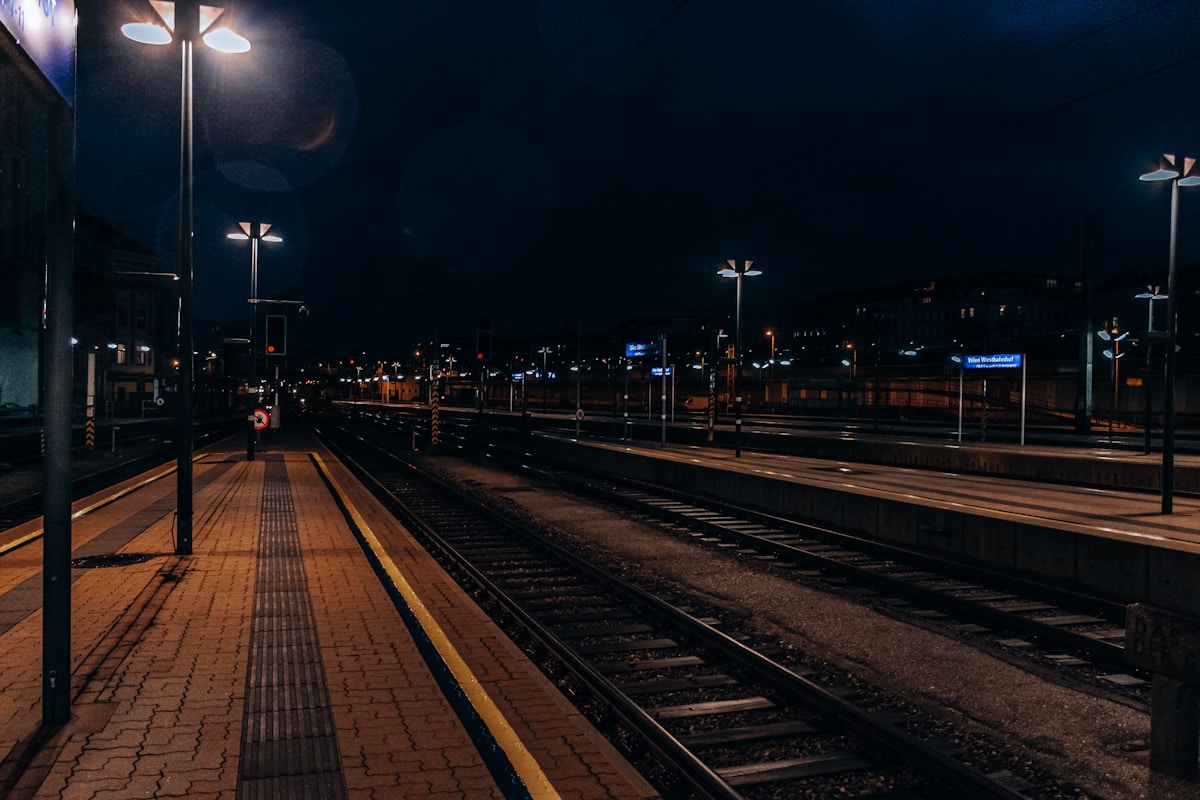 Night train at a railway station platform with overhead lights