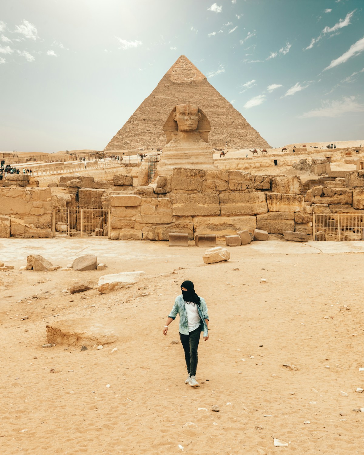 Personne marchant devant le Grand Sphinx et la Pyramide de Gizeh, Égypte
