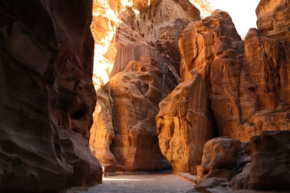 Sunlight streaming through the narrow Siq canyon at Petra, Jordan